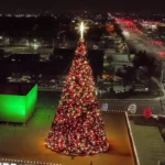 38-foot commercial Christmas panel tree with red and warm white lights installed outdoors at night