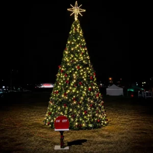 50-foot commercial Christmas panel tree with warm white lights and red ornaments installed outdoors at night