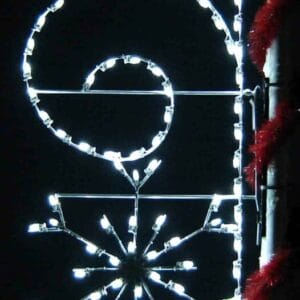 8-foot snowflake with scroll pole mount holiday light display illuminated on a decorated pole at night