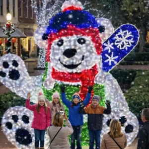 Children posing before illuminated polar bear holiday display