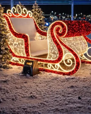Illuminated Christmas sleigh decoration in snowy night setting