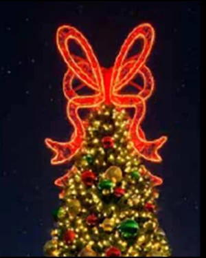 Christmas tree topped with glowing red bow