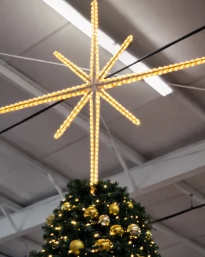 Illuminated star atop decorated Christmas tree indoors