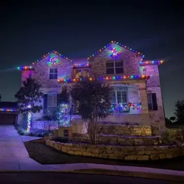 Two-story house decorated with colorful Christmas lights
