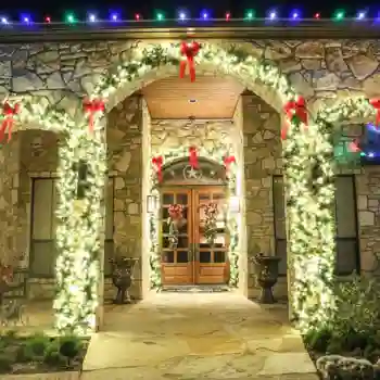 Stone house entrance decorated with commercial Christmas garland
