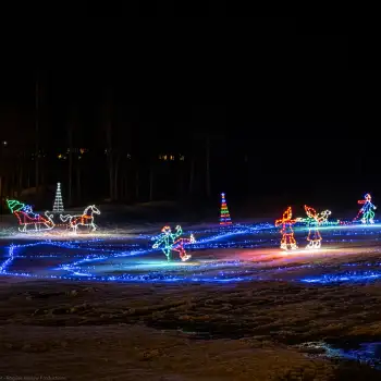 Colorful holiday Commercial Christmas light display on snowy ground at night