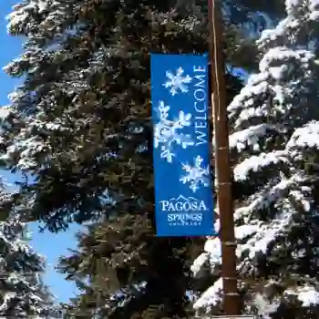 Snowy trees and commercial winter street banner in Pagosa Springs