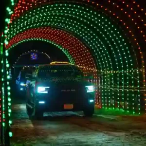 SUV driving through a RGB commercial Christmas light tunnel