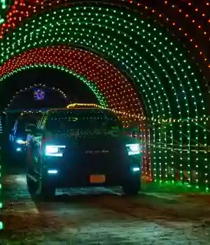 SUV driving through commercial rgb drive through tunnel at night