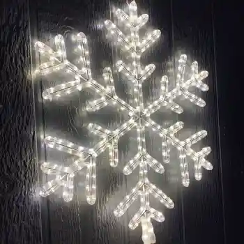 Illuminated commercial snowflake light decoration on dark wall