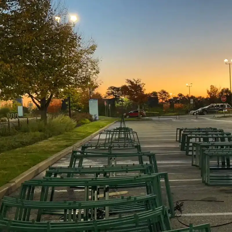 Stacked green metal stands in parking lot at sunset