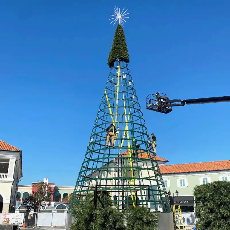 Workers assembling large outdoor Christmas tree frame