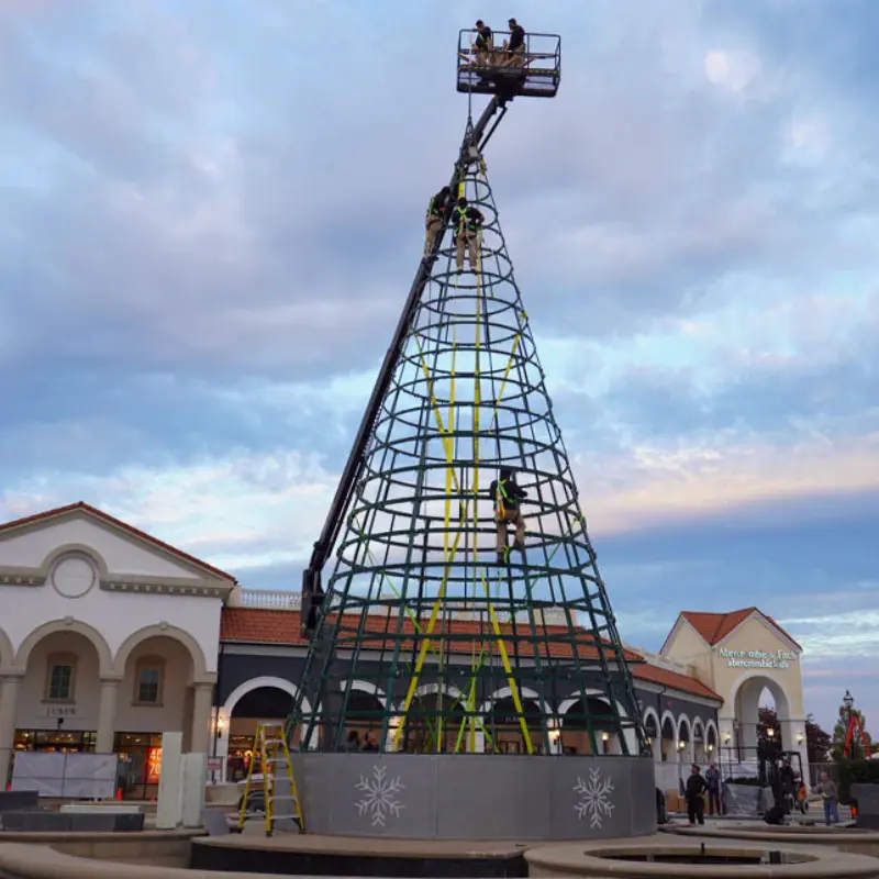 Workers assembling large outdoor Christmas tree frame