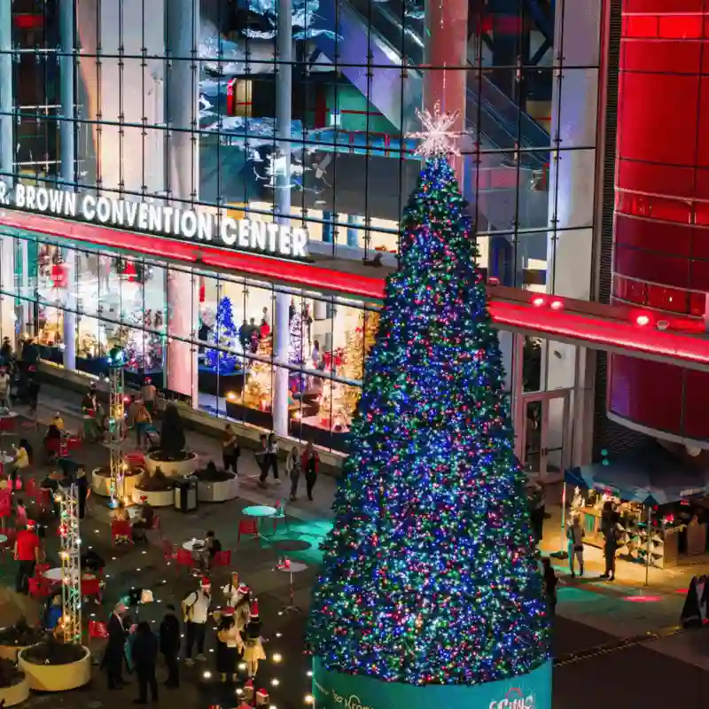 Large illuminated Christmas tree outside convention center at night