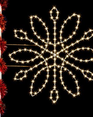 Illuminated snowflake light decoration on pole at night