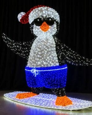 Light-up penguin surfing in Santa hat