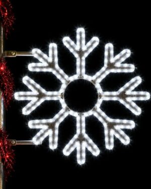 Illuminated snowflake holiday decoration on lamppost at night
