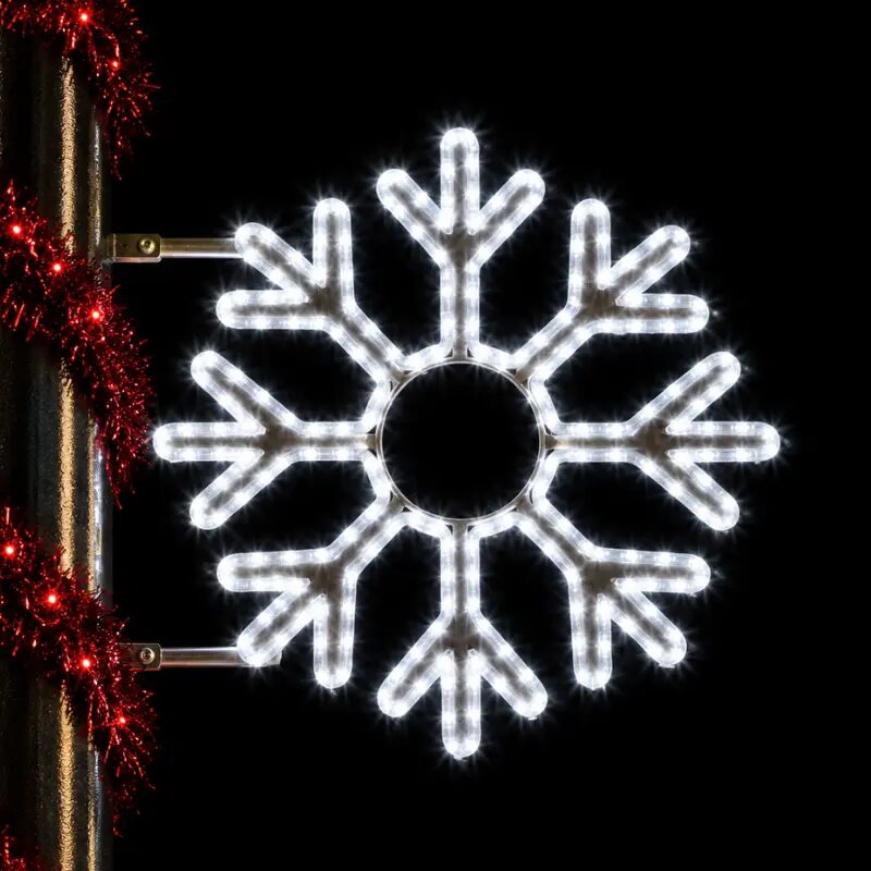 Illuminated snowflake holiday decoration on lamppost at night