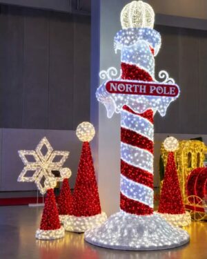 Illuminated North Pole Christmas display with candy cane pole