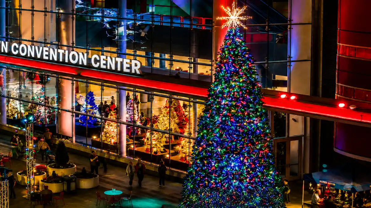 Illuminated Christmas tree outside a convention center at night