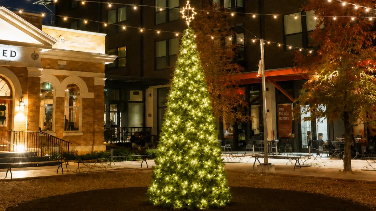 Lit Christmas tree in a festive urban plaza at night